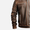 Detail of brown leather jacket showing stitched shoulder panel, sleeve and lower zip pocket