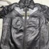 Front of men's black leather jacket with white eagle chest embroidery, shirt collar and zip pockets